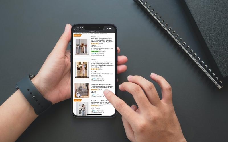 A user on their iPhone using the Amazon app to shop for pet gates