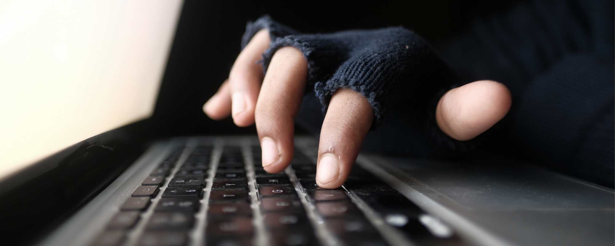 Person with gloves on typing on a laptop keyboard -12 Ways Merchants Get Your Inventory (And what you can do about it!)